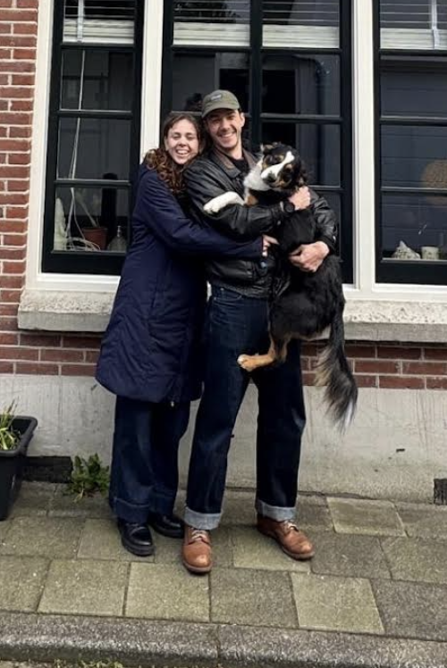 Baptiste and his partner with their dog in front of their new Amsterdam home